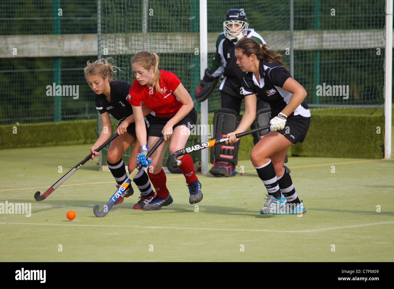 Female hockey players in action on an astro turf pitch Stock Photo