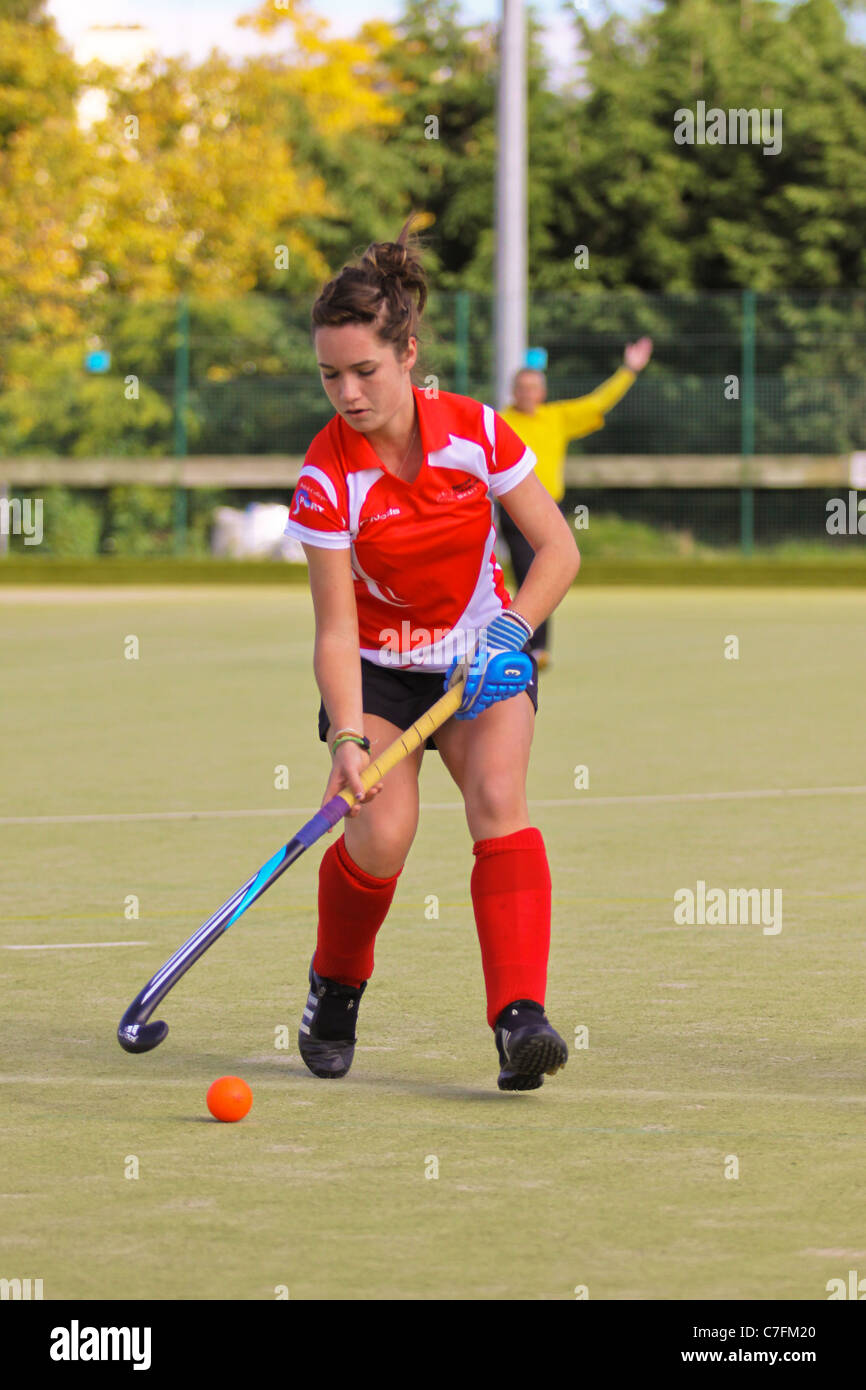 A female hockey player in action on an astro turf pitch Stock Photo