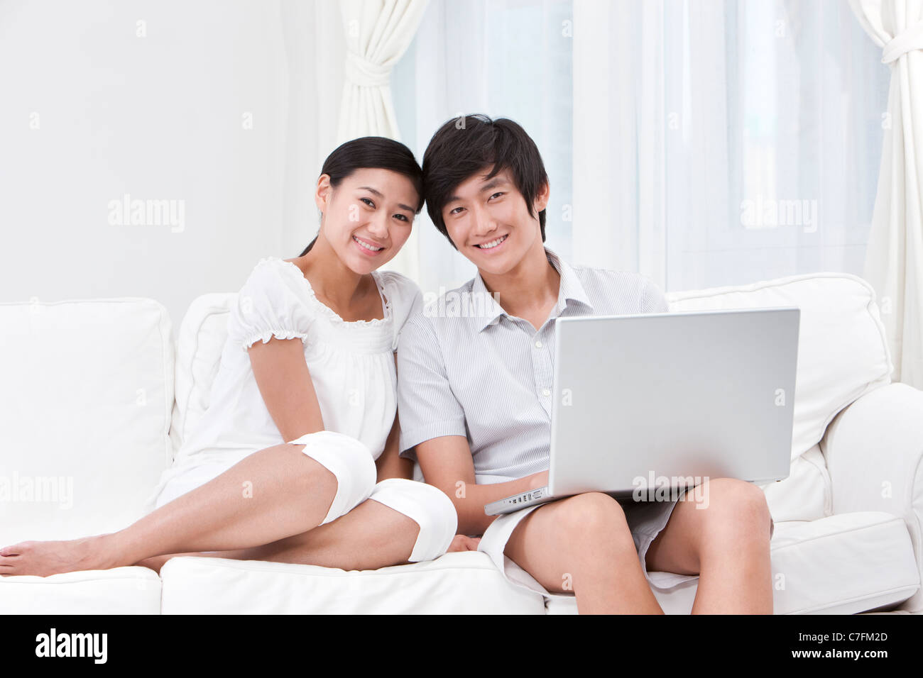 Young Couple Using Laptop at Home Stock Photo - Alamy