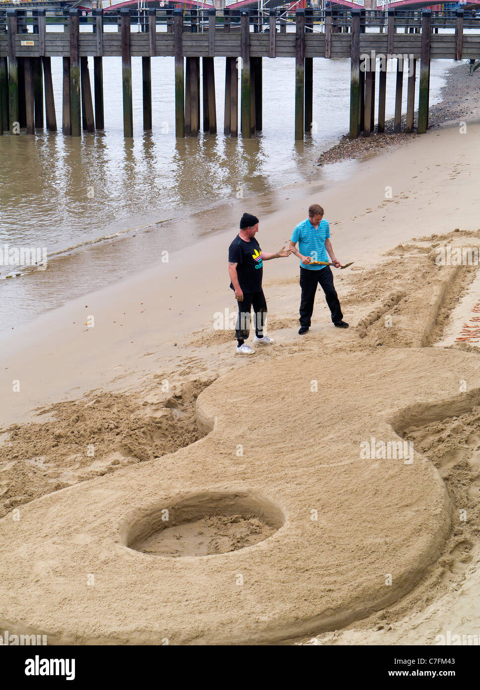 Building a giant guitar sand castle at low tide 2 - Thames Festival 2011 Stock Photo