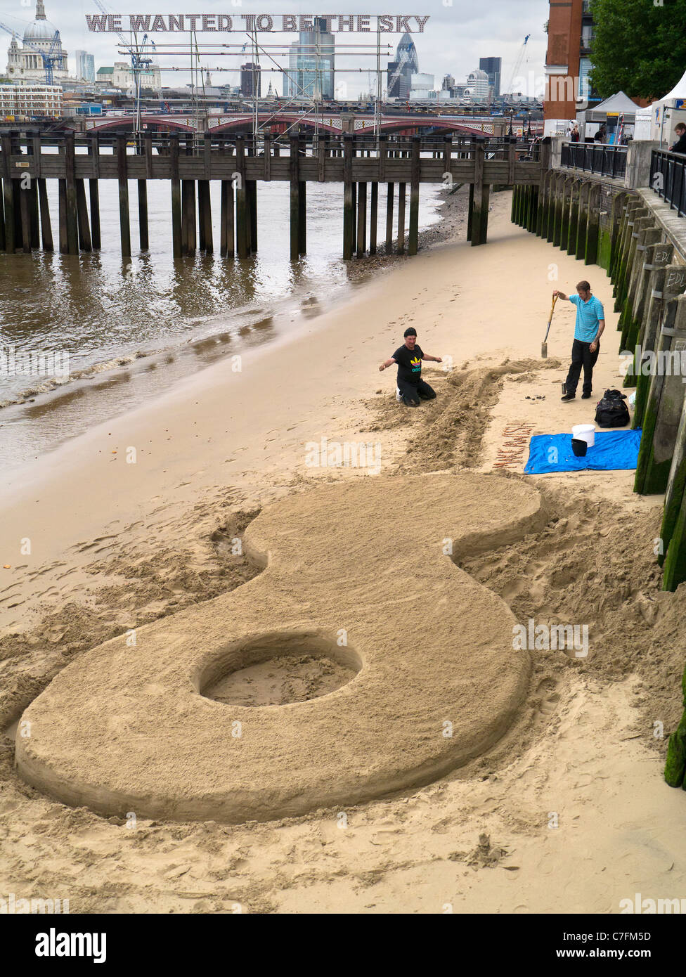 Building a giant guitar sand castle at low tide 4 - Thames Festival 2011 Stock Photo