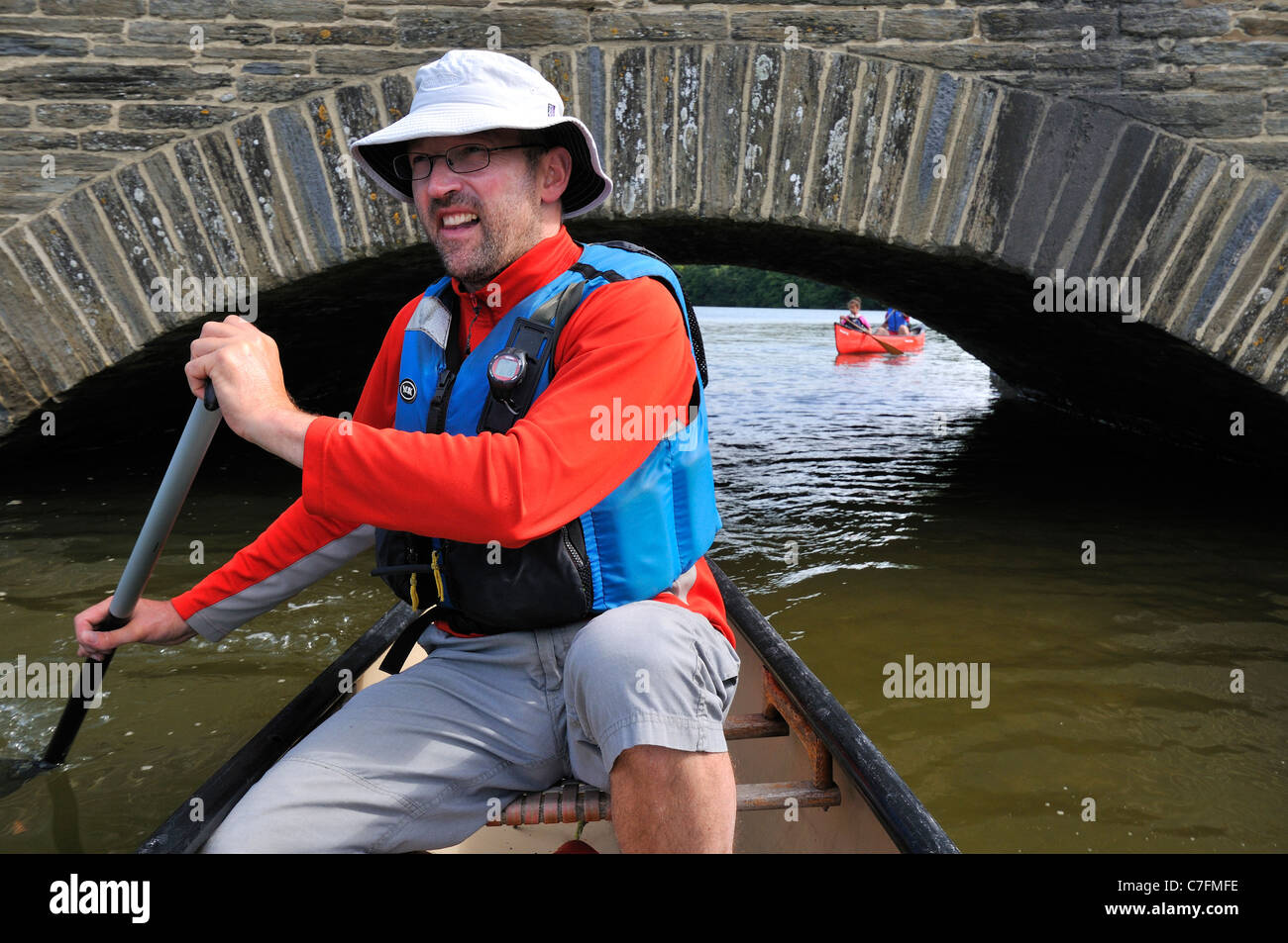 Digging in the paddle in single paddle canoe on safari at New Bridge