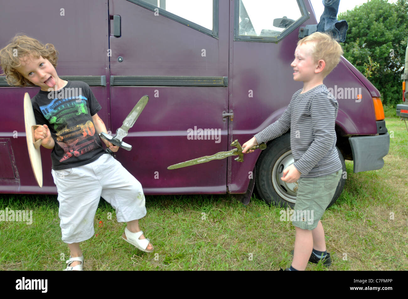 Two boys playing with wooden swords Stock Photo
