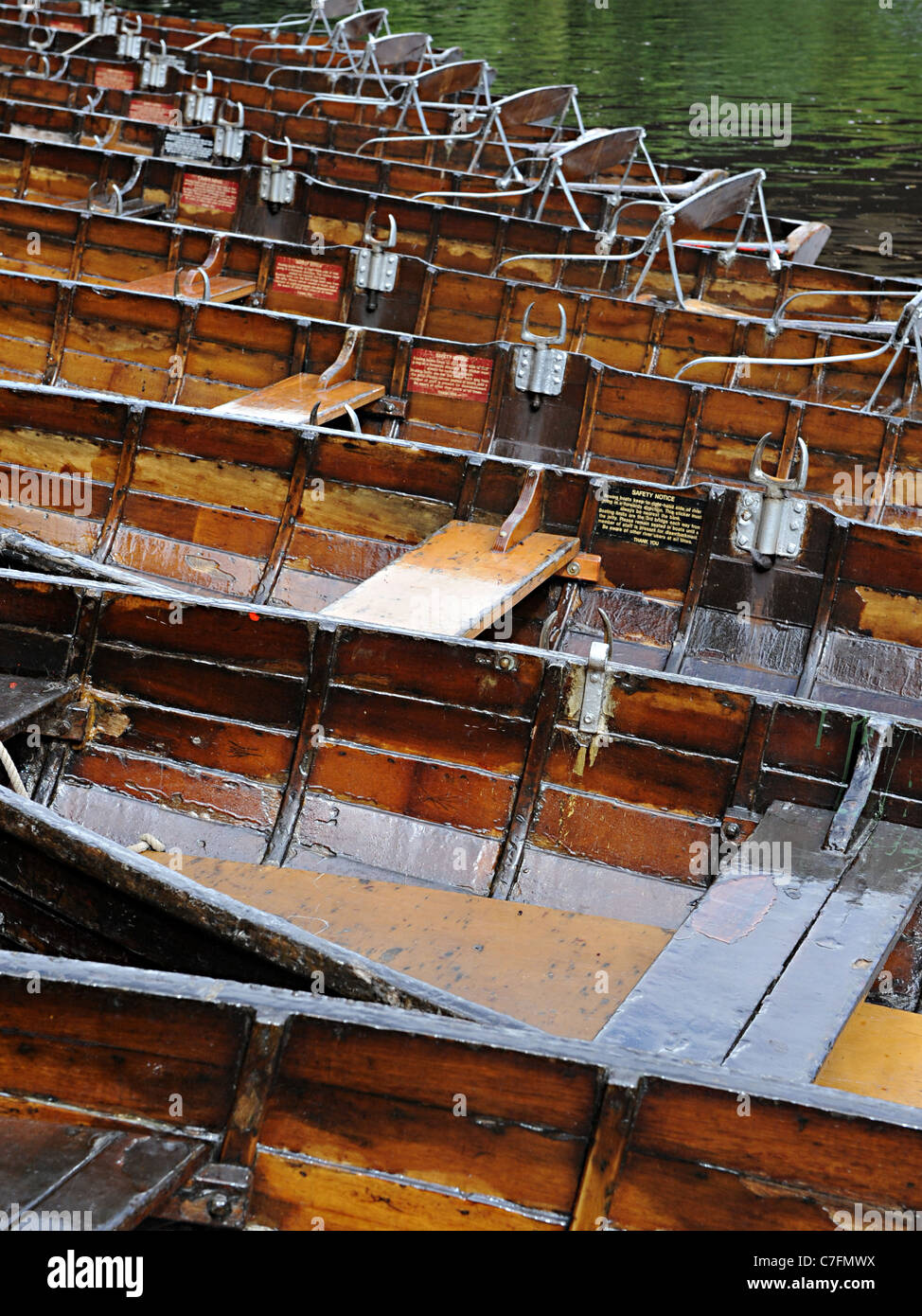 A line of old wooden punts on the river wear in Durham near the Durham University Stock Photo