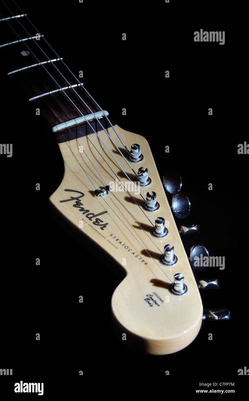 Fender stratocaster custom build guitar fret and head lit with directional light on black background. Stock Photo