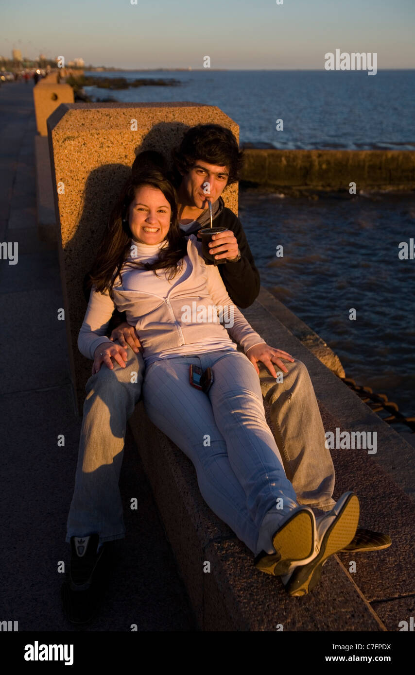 Young couple drinking mate along the rambla in Montevideo Uruguay Stock Photo