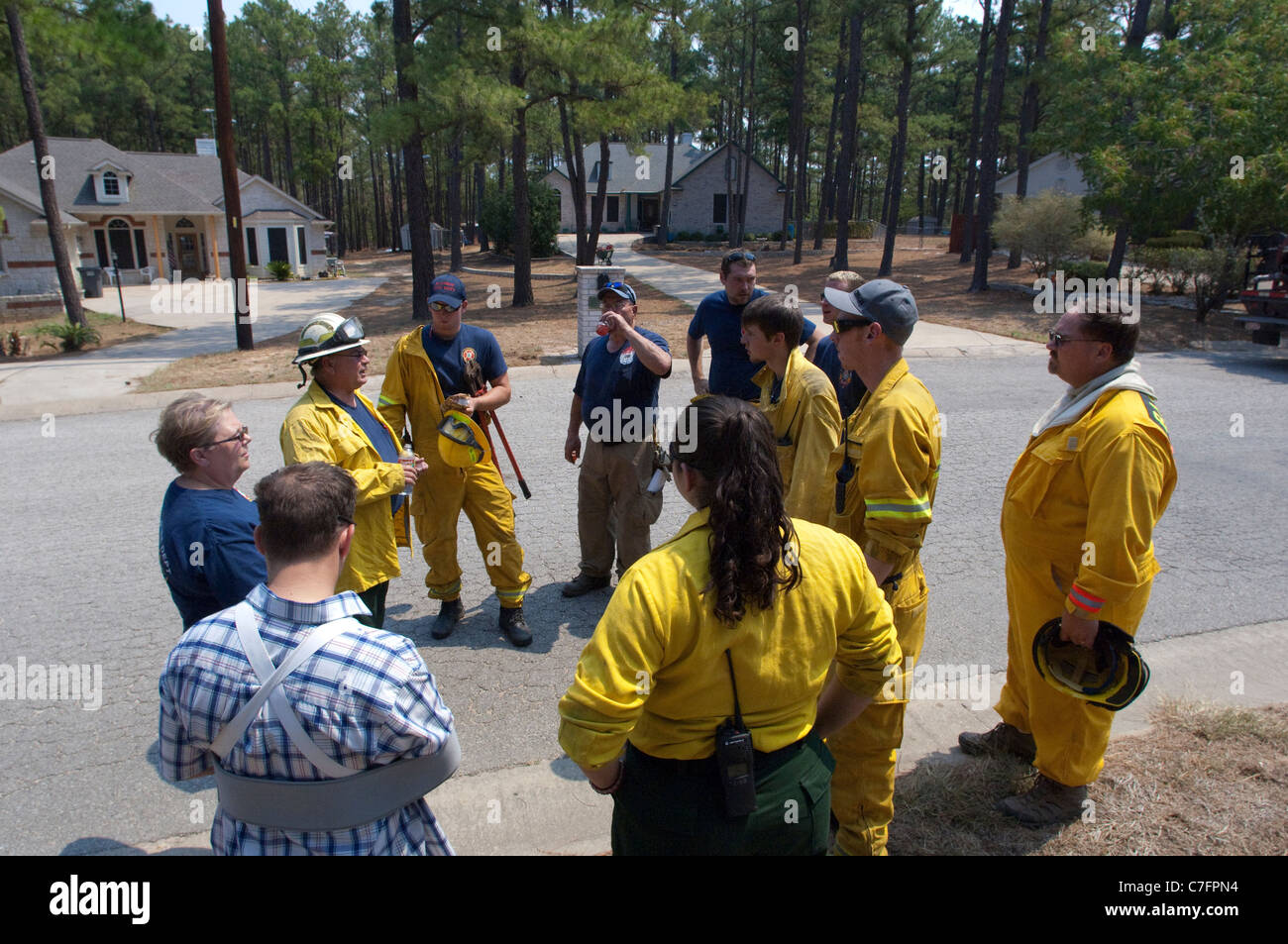 Fire fighters plot strategy before battling a wildfire approaching this neighborhood along Texas Hwy. 21 near Bastrop Stock Photo