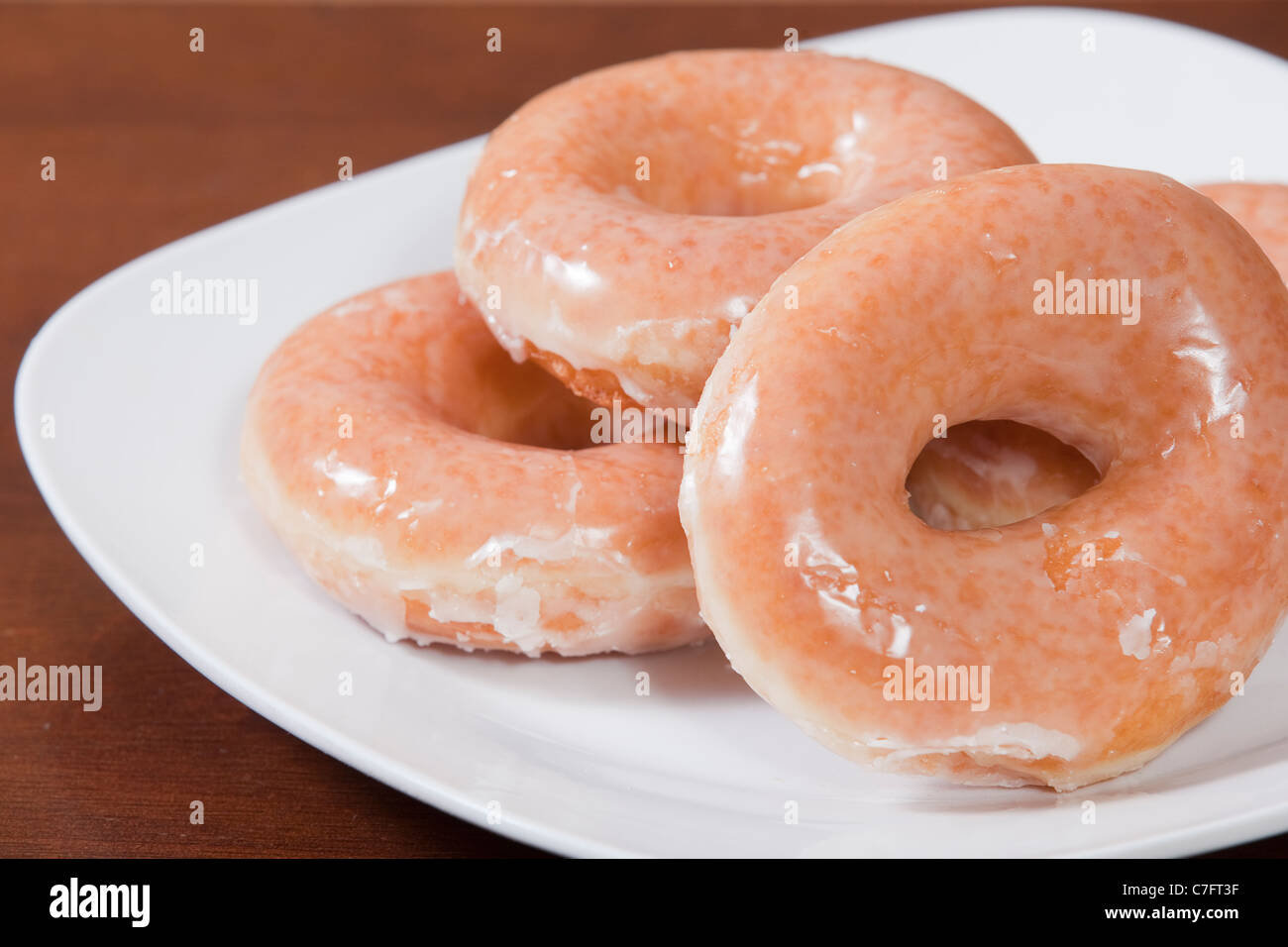 Plate full of a half a dozen glazed donuts Stock Photo Alamy