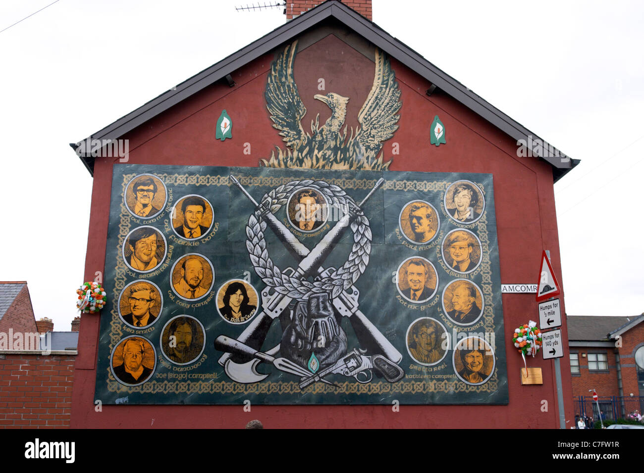 republican wall to dead ira volunteers featuring phoenix and crossed rifles mural painting west belfast northern ireland Stock Photo