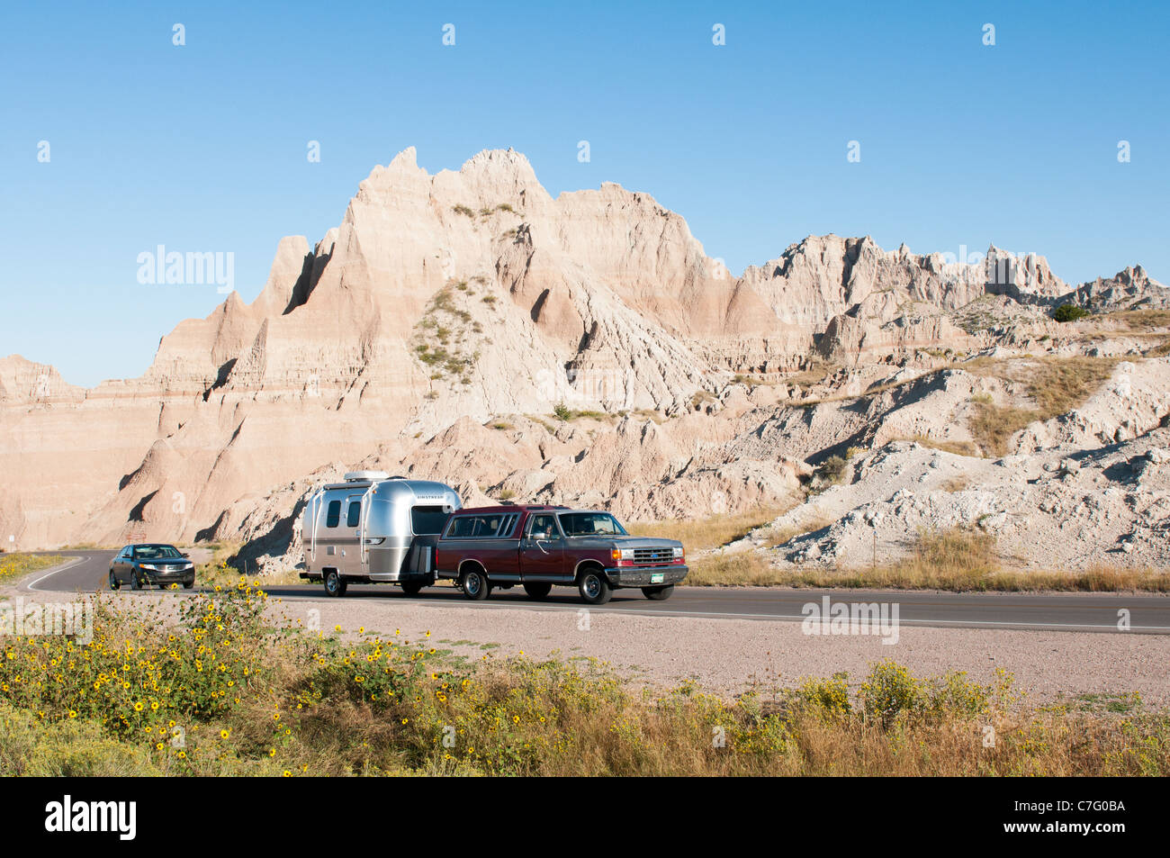 Tourists in a recreational vehicle drive through Badlands National Park