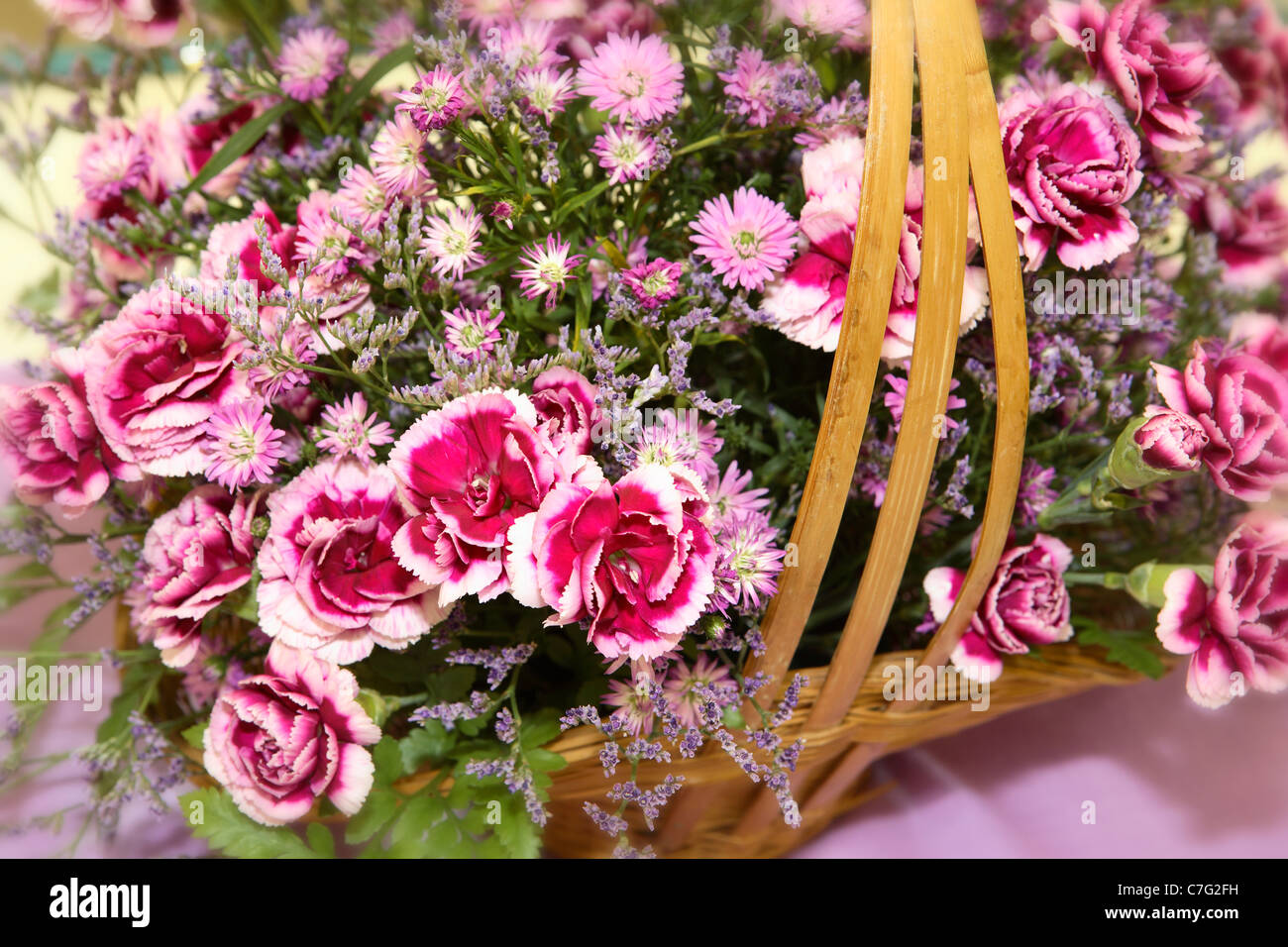 Red Pink flowers in cane basket detail Stock Photo Alamy