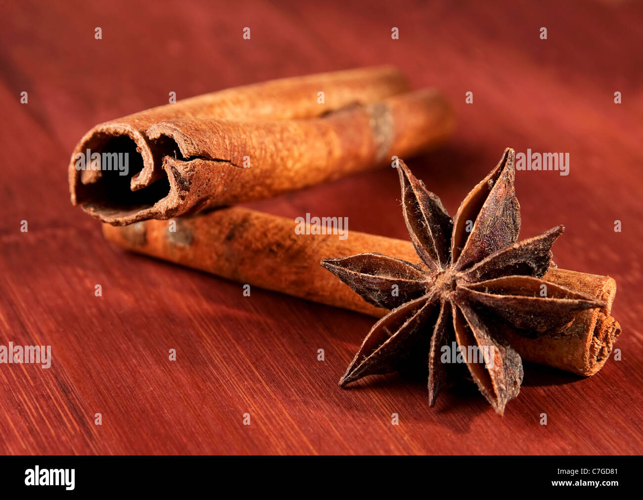 Stick of cinnamon with anise closeup on brown board Stock Photo