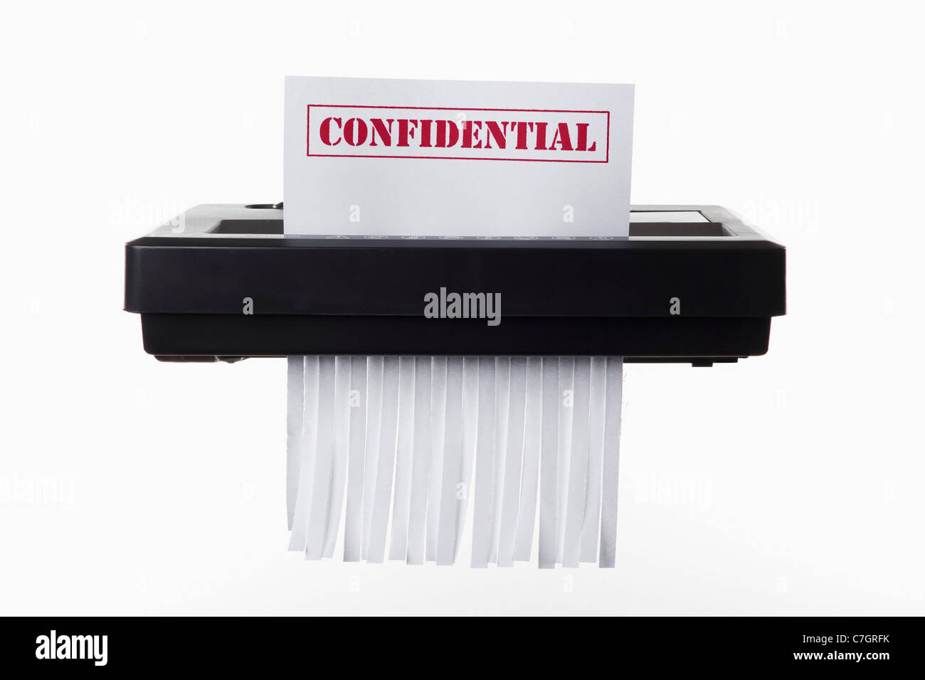 A document with CONFIDENTIAL on it being shredded in a paper shredder Stock Photo