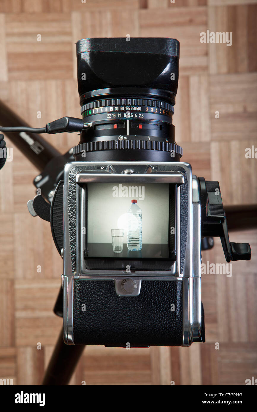 A medium format camera photographing a glass next to bottled water Stock Photo