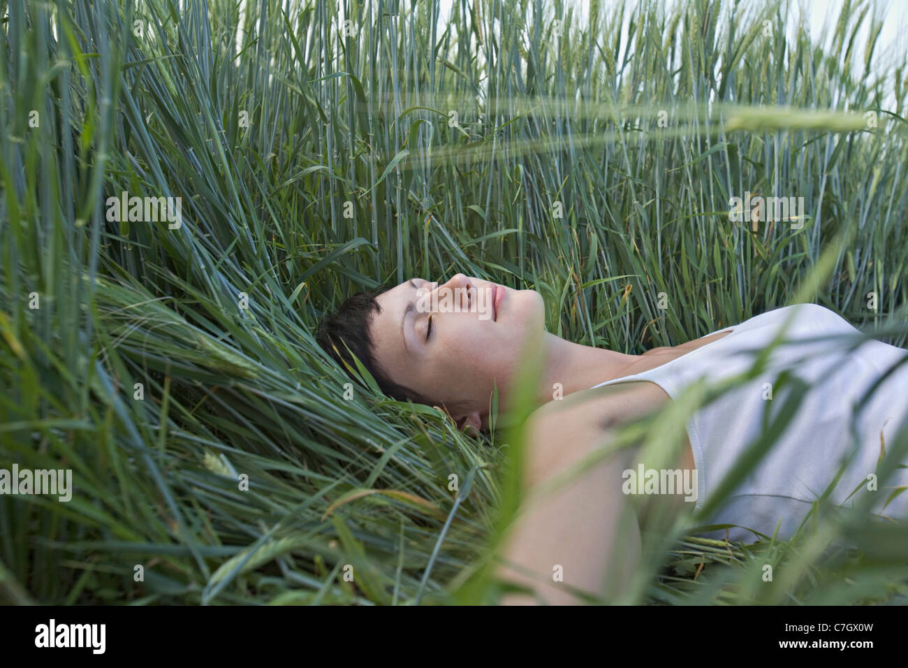 A woman sleeping in grass Stock Photo