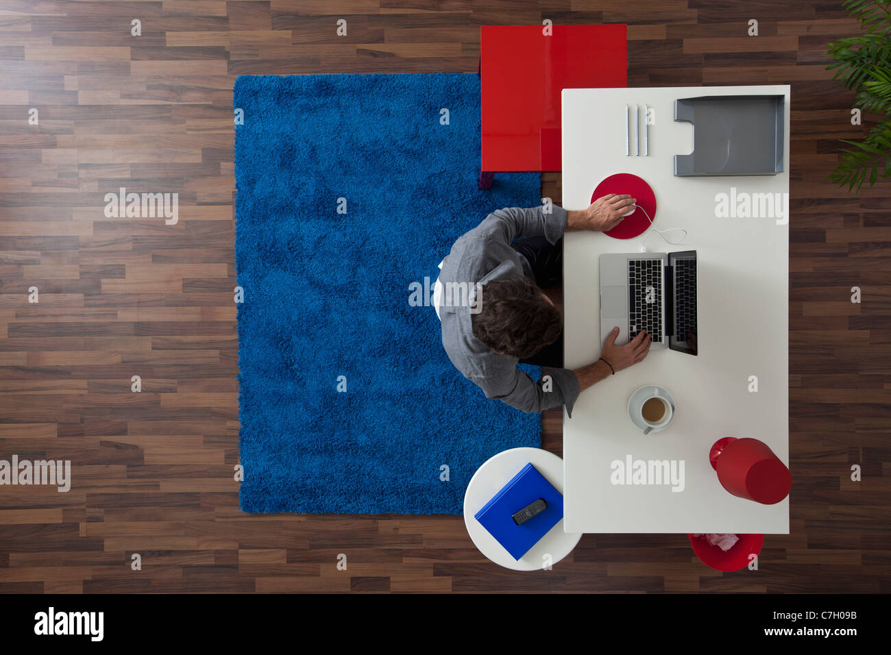 A businessman working at his desk in his home office, overhead view