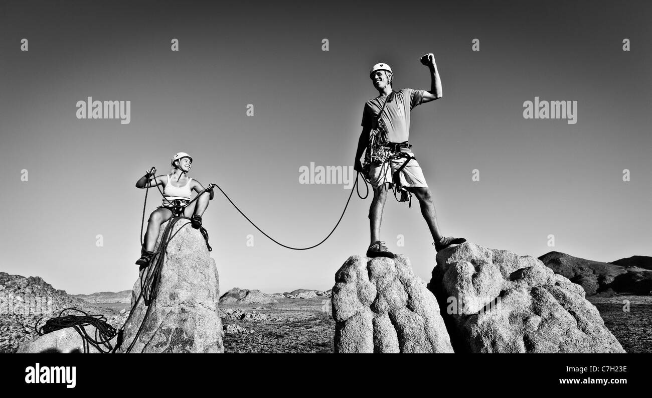 Team of rock climbers struggle to the summit of a challenging cliff. Stock Photo