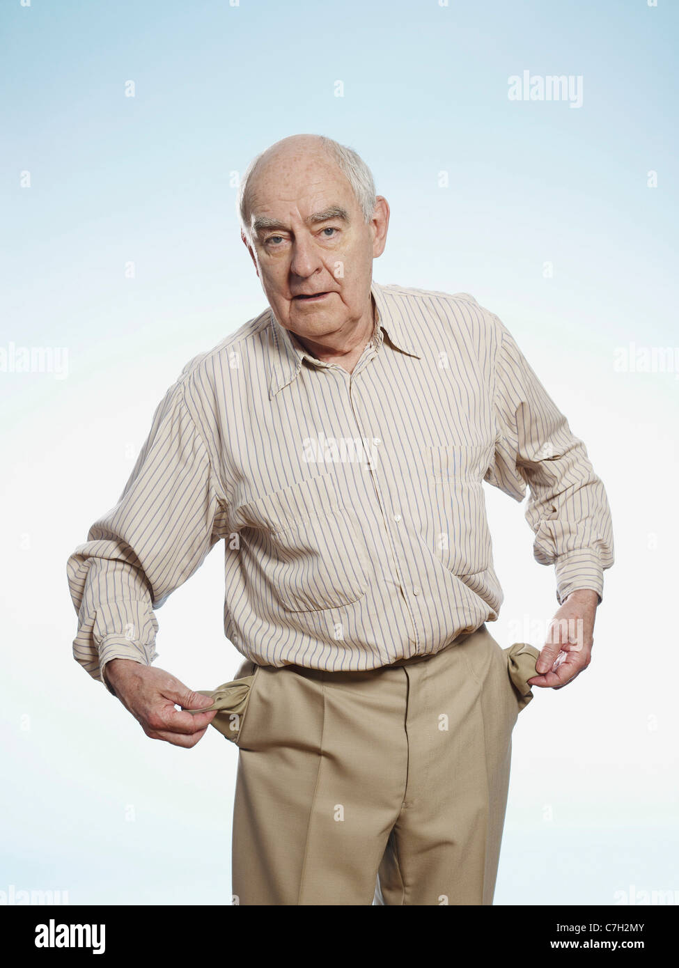 Senior man turns his pockets inside out to symbolize having no money