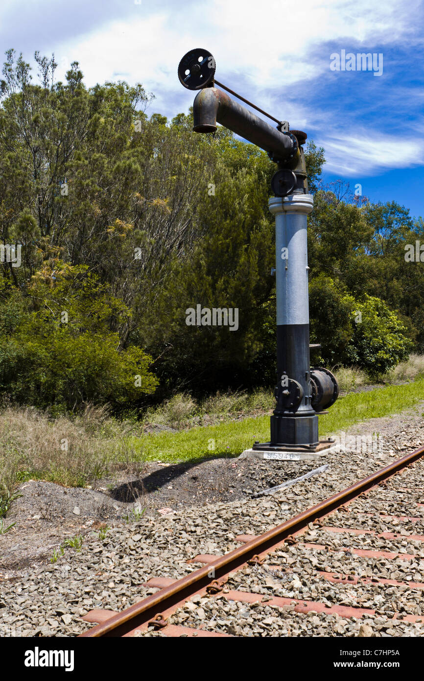 A water crane beside railroad tracks Stock Photo