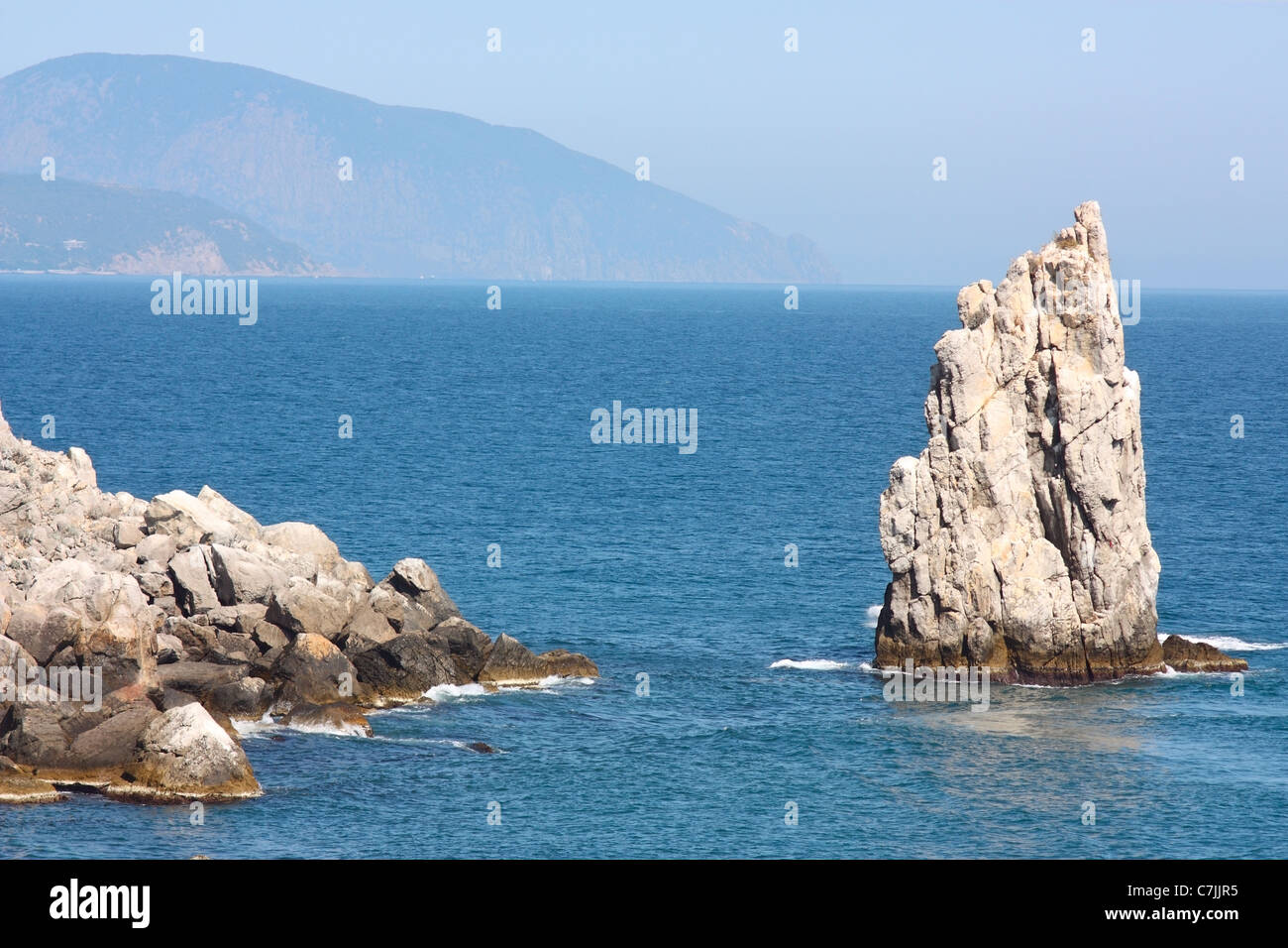 Southern coast of Crimea. Black Sea, Rock 'Sail', a mountain in the background 'Ajudag' (Bear Mountain) Stock Photo