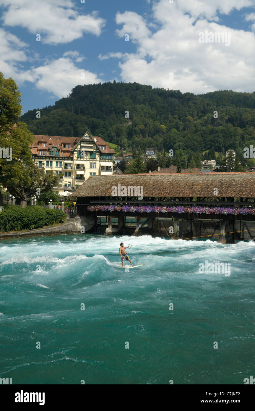 Switzerland, Canton of Bern, Thun. Surfer in the escaping water behind one of the river Aare historic locks. Stock Photo