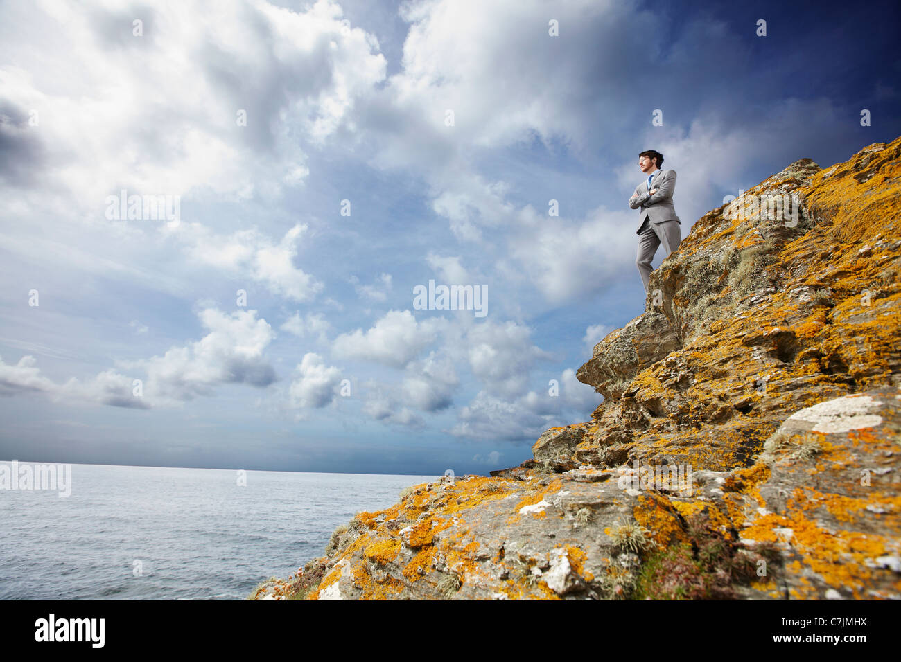 Businessman standing on cliff edge Stock Photo