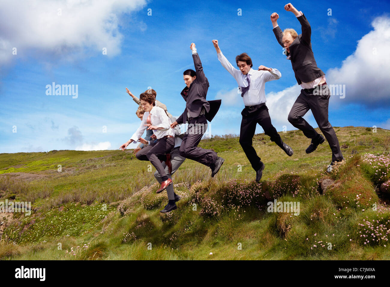 Businessmen jumping for joy outdoors Stock Photo