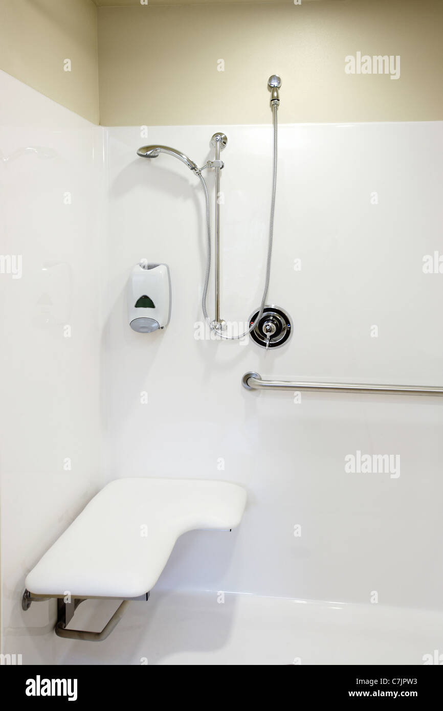 An image of the safety bars, seat and plumbing fixtures in a roll in shower stall Stock Photo