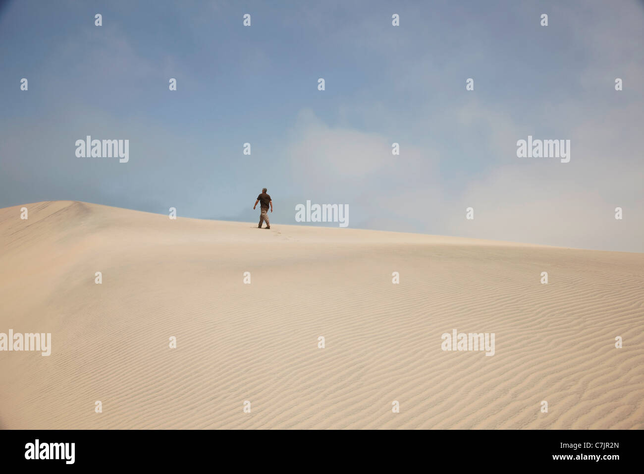 Man walking on sand dunes Stock Photo Alamy