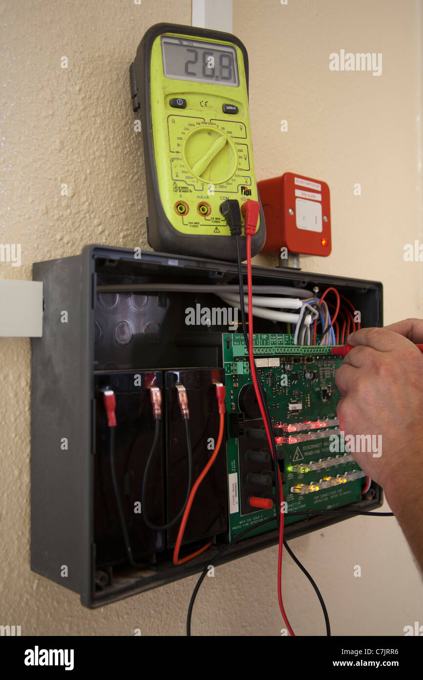 Electrician using Metering Equipment Fault finding on a Fire Alarm