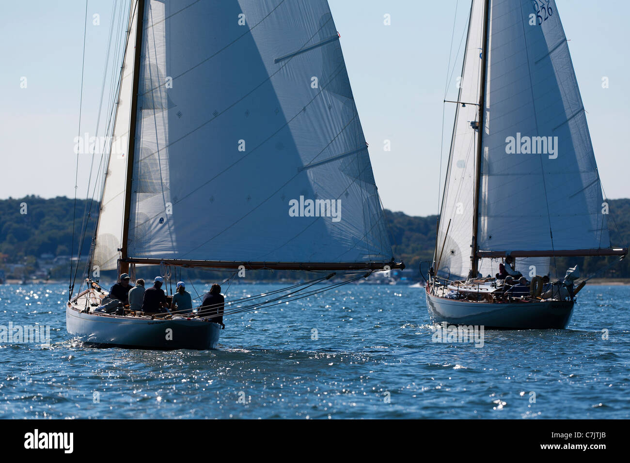Two classic wooden sailing yachts racing downwind in light wind on