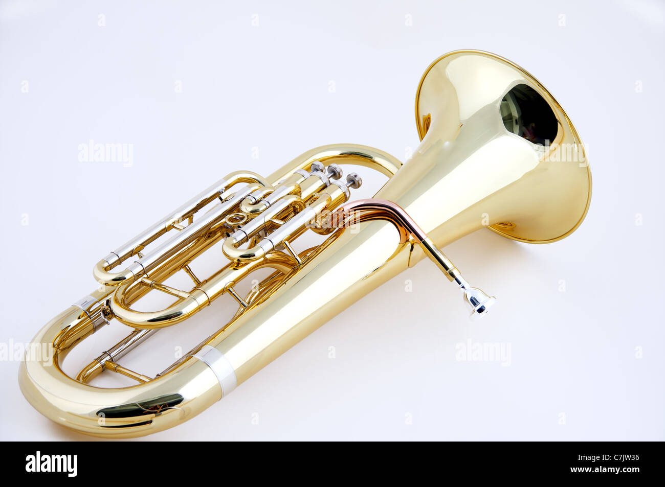 A complete gold brass tuba or euphonium isolated against a high key white background in the horizontal format with copy space. Stock Photo