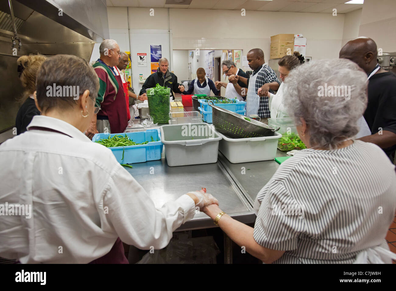 Volunteers Pray Before Serving Breakfast at Soup Kitchen Stock Photo