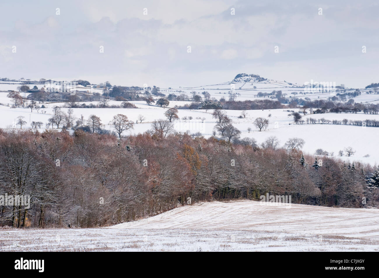 Snowy scenic winter view (snow-covered farmland fields, woodland trees, Almscliffe Crag, distinctive high rocky outcrop) - North Yorkshire, England UK Stock Photo
