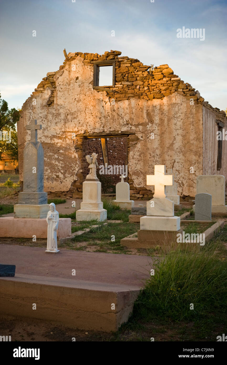 The adobe Saint Rose of Lima Chapel and cemetery, built in the early 1800's, glows in the setting sun in Santa Rosa, New Mexico. Stock Photo