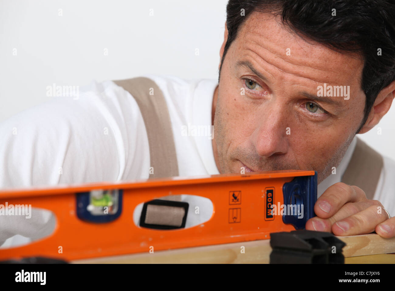 Man with spirit level Stock Photo - Alamy