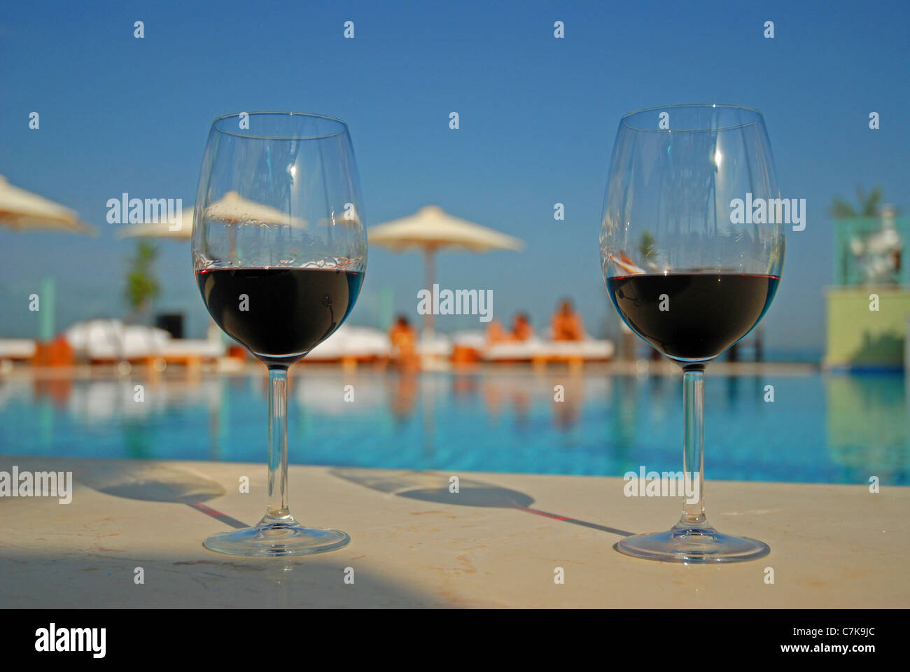 Wine glasses and a luxury swimming pool in a tropical resort Stock