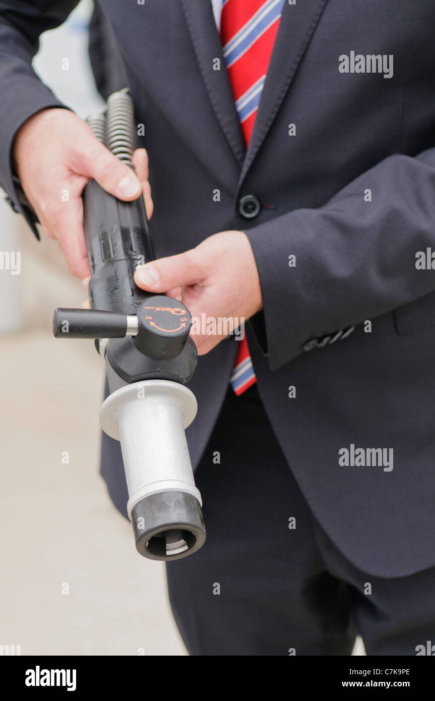 Man holding a hydrogen fuel filler nozzle for refueling hydrogen powered vehicles Stock Photo