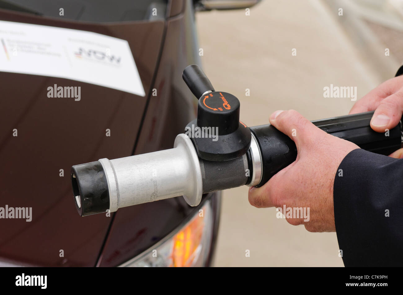 Man holding a hydrogen fuel filler nozzle for refueling hydrogen powered vehicles Stock Photo