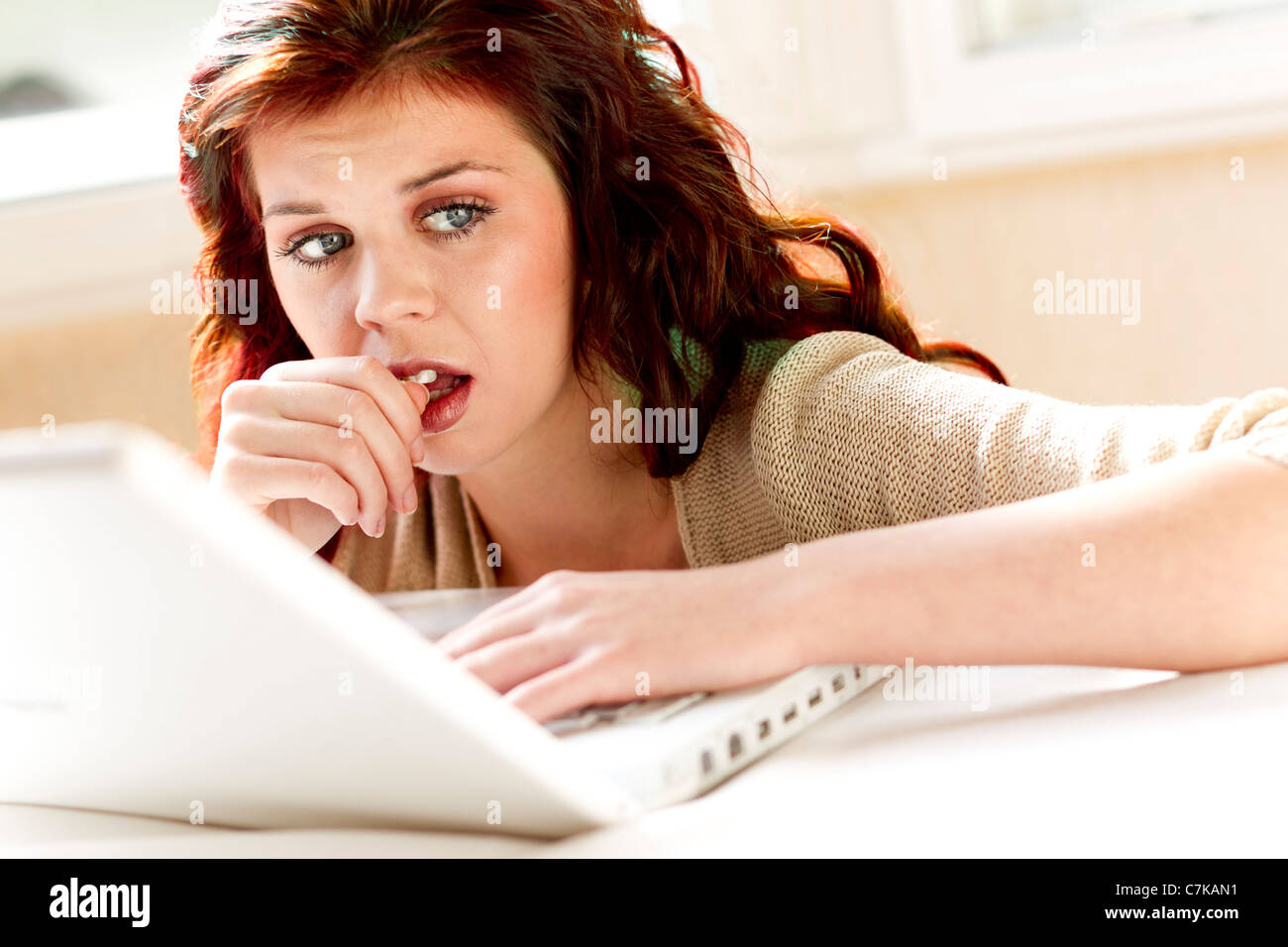 Girl looking thoughtful using laptop Stock Photo
