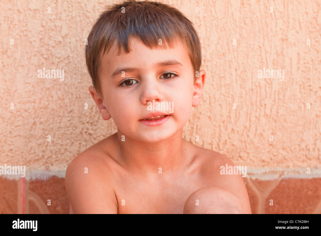 Little boy standing in front of a wall Stock Photo