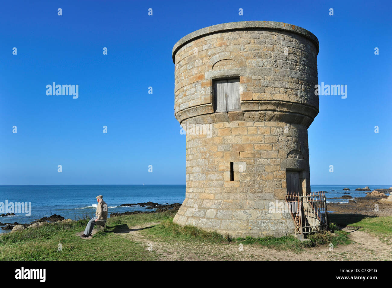 Old man looking at the sea and watchtower along the Côte Sauvage near Le Croisic, Loire-Atlantique, Pays de la Loire, France Stock Photo