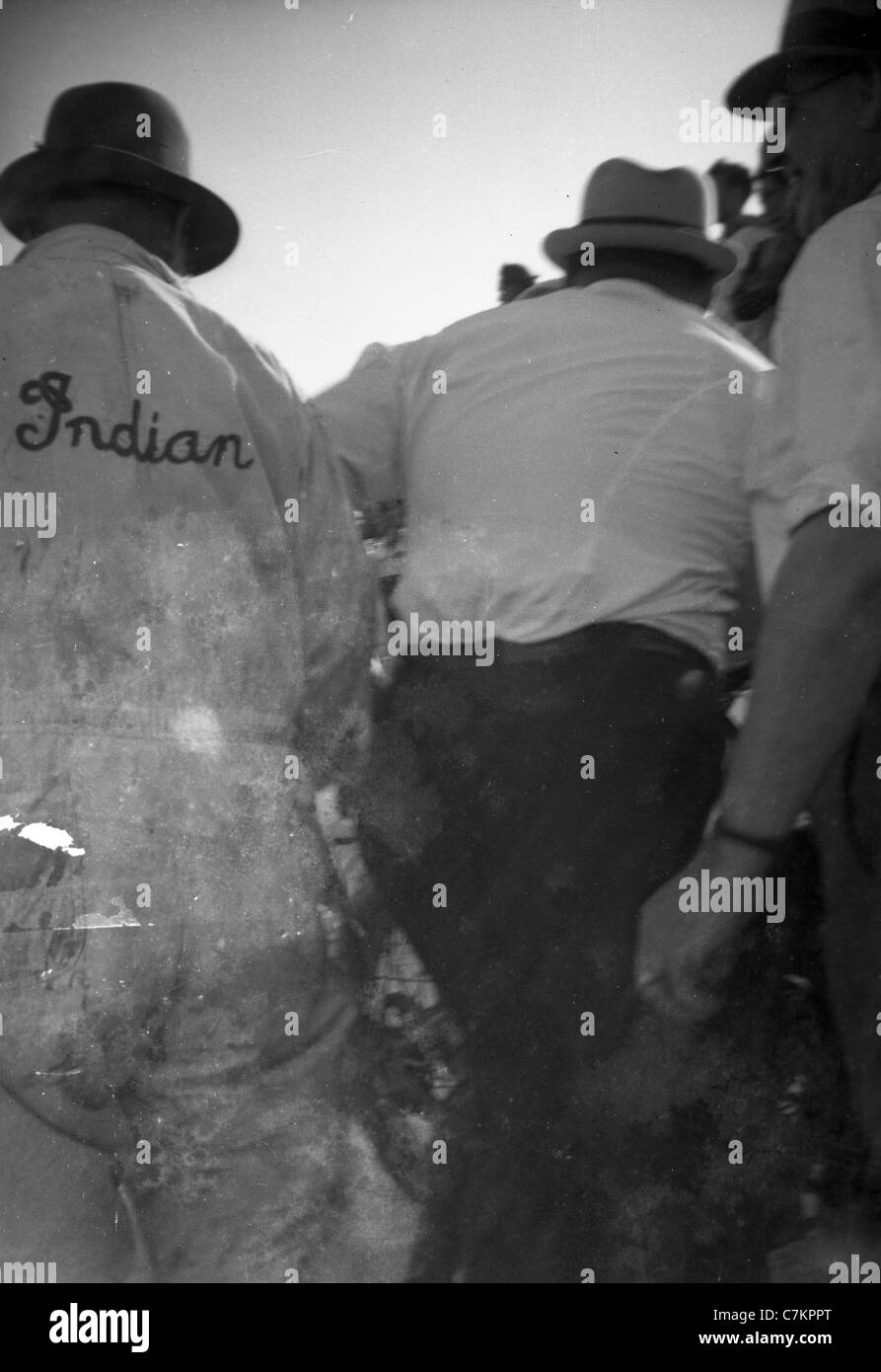 A motorcycle maintenance worker wears a set of overalls with the word, 'Indian,' during a motorcycle race during the 1930s. Stock Photo