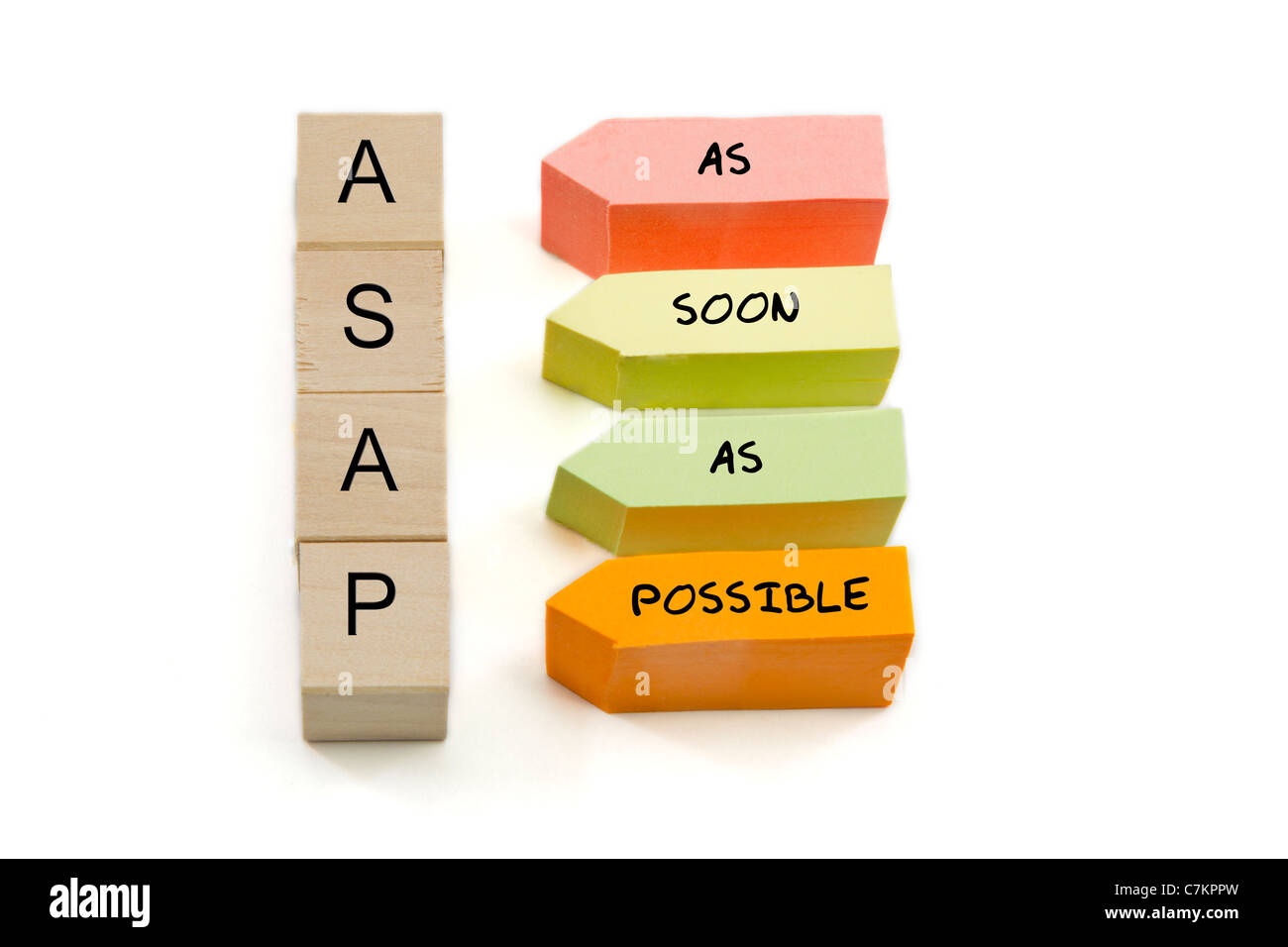 ASAP, As Soon As Possible spelled out on wooden blocks and colorful arrow shaped sticky notes. Stock Photo