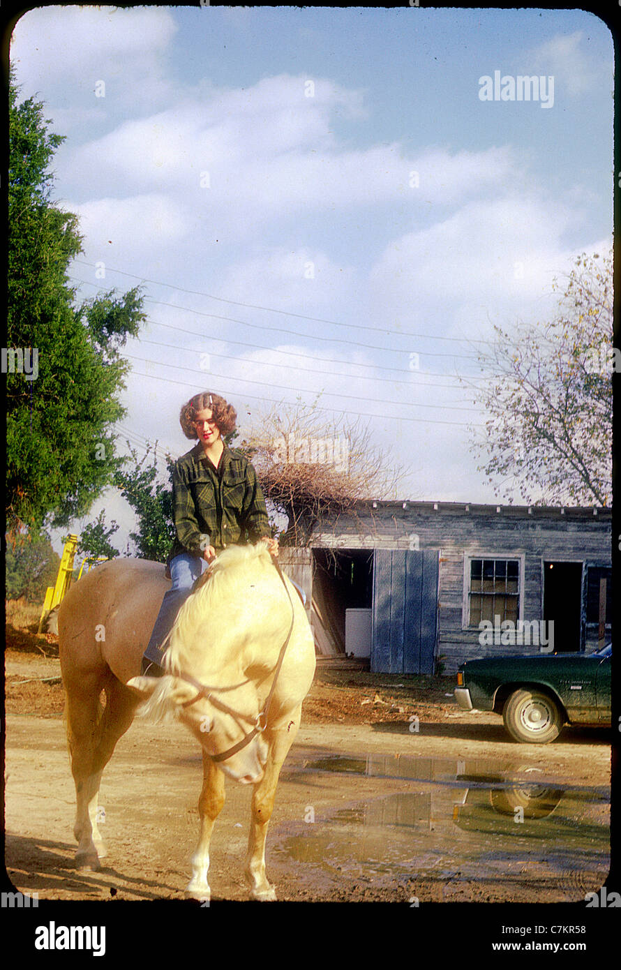 pretty teenage girl on horse red lipstick fashion south southern girl yellow 1960s Americana Stock Photo