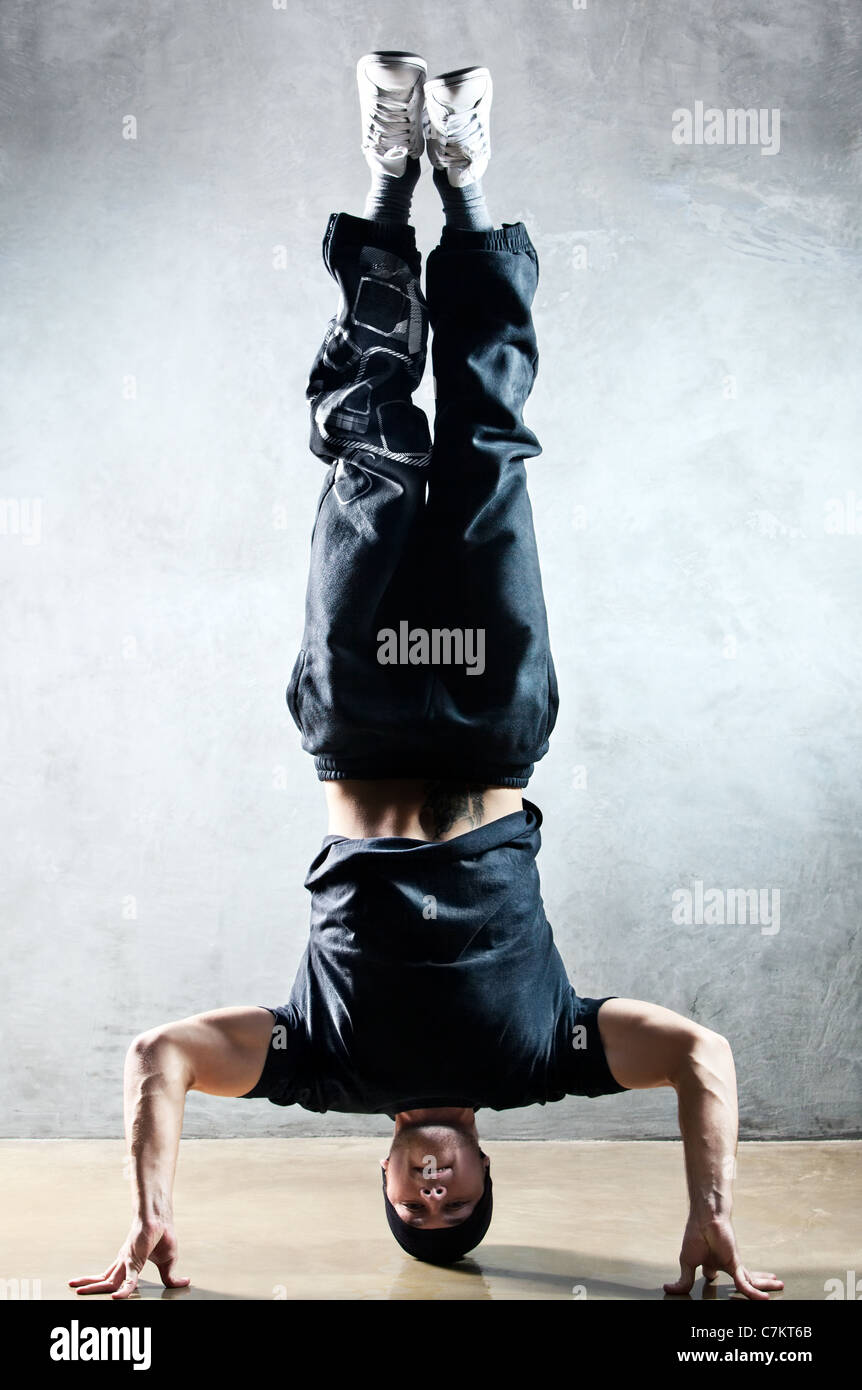 Young strong man standing on head Stock Photo Alamy
