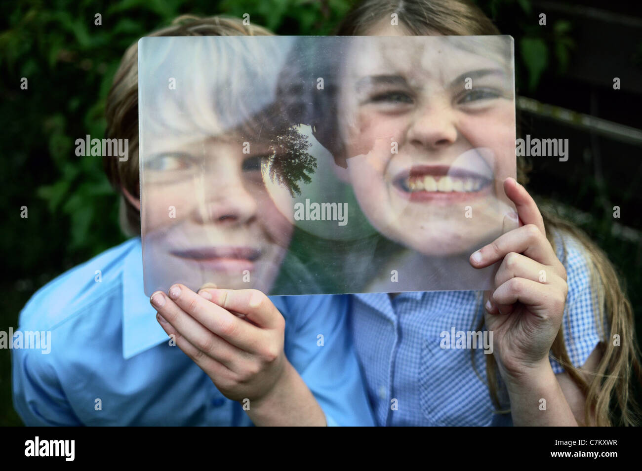 a boy and a girl looking through a Fresnel lens Stock Photo