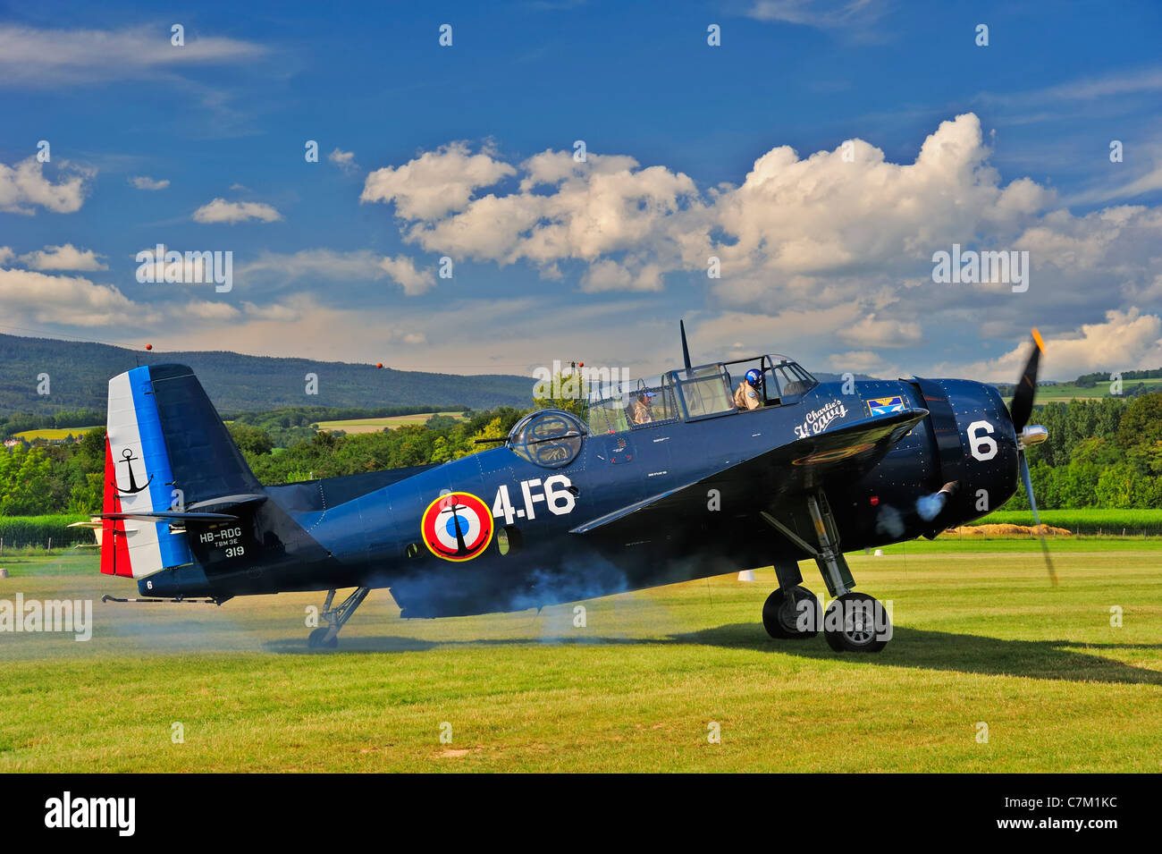 An historic Grumman TBM-3E 'Avenger' torpedo bomber starting up its engines (see puff of smoke) ready for take-off Stock Photo