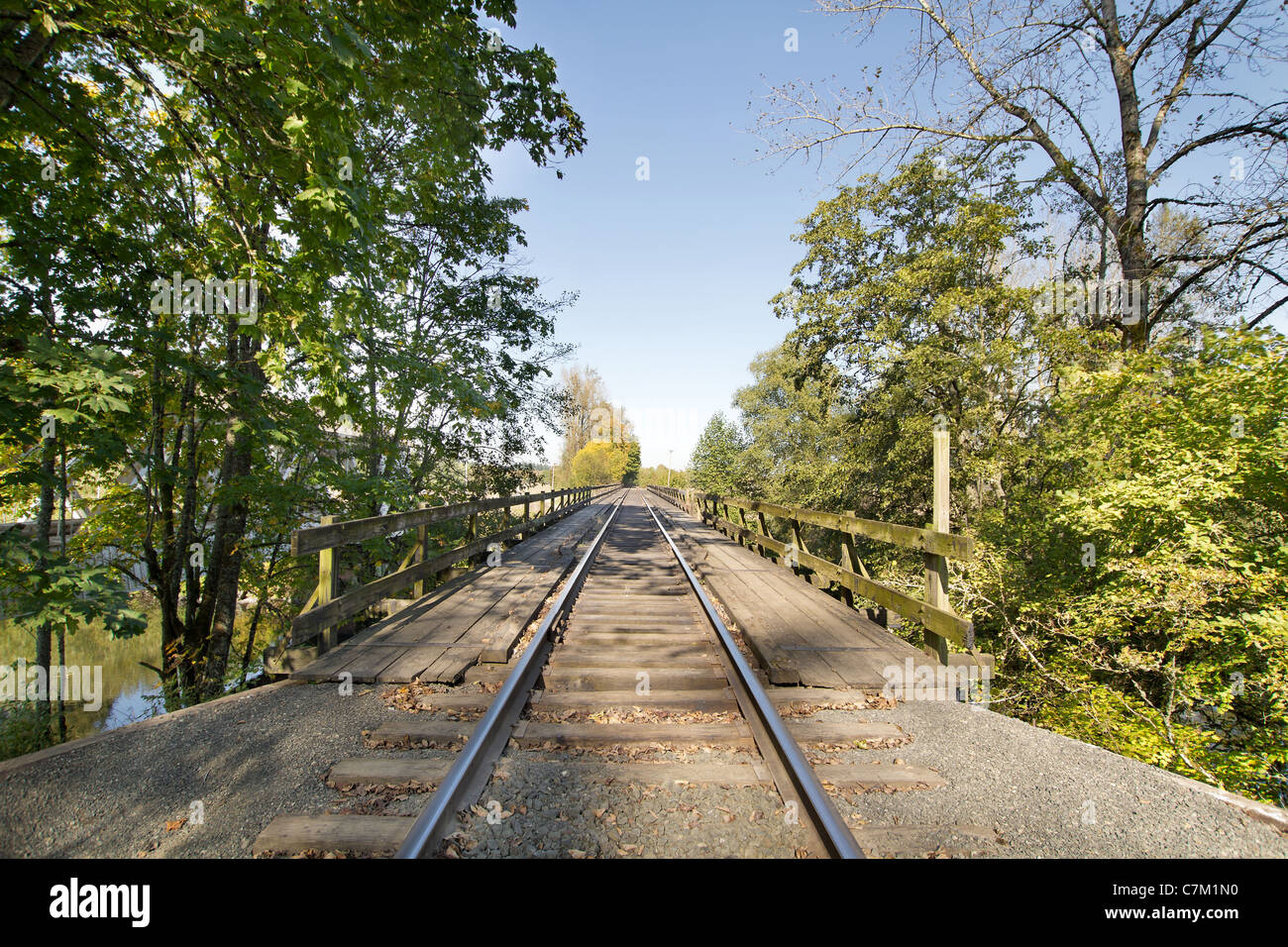 Train Track on Wooden Bridge over River in Oregon Stock Photo
