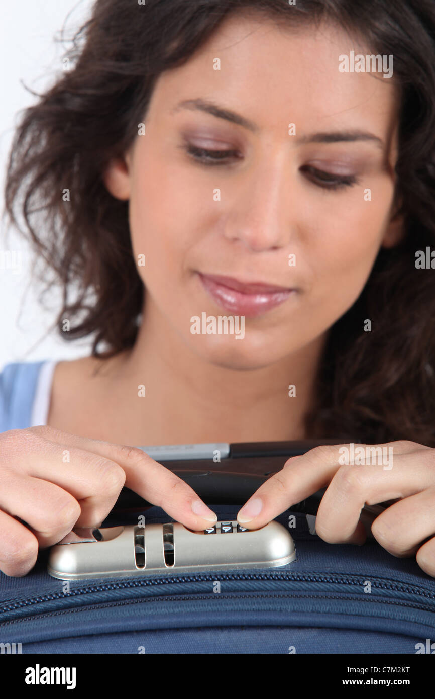 Woman unlocking the combination on her suitcase Stock Photo